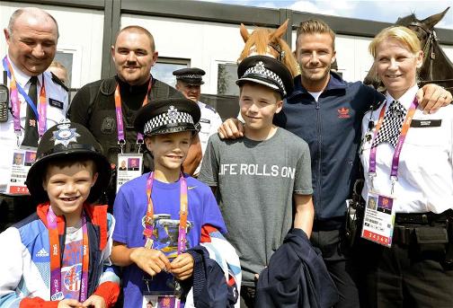 BECKHAM'S LAW: David Beckham and his sons Cruz, Romeo and Brooklyn  pose with police officers who are assisting with security at the Olympic Games